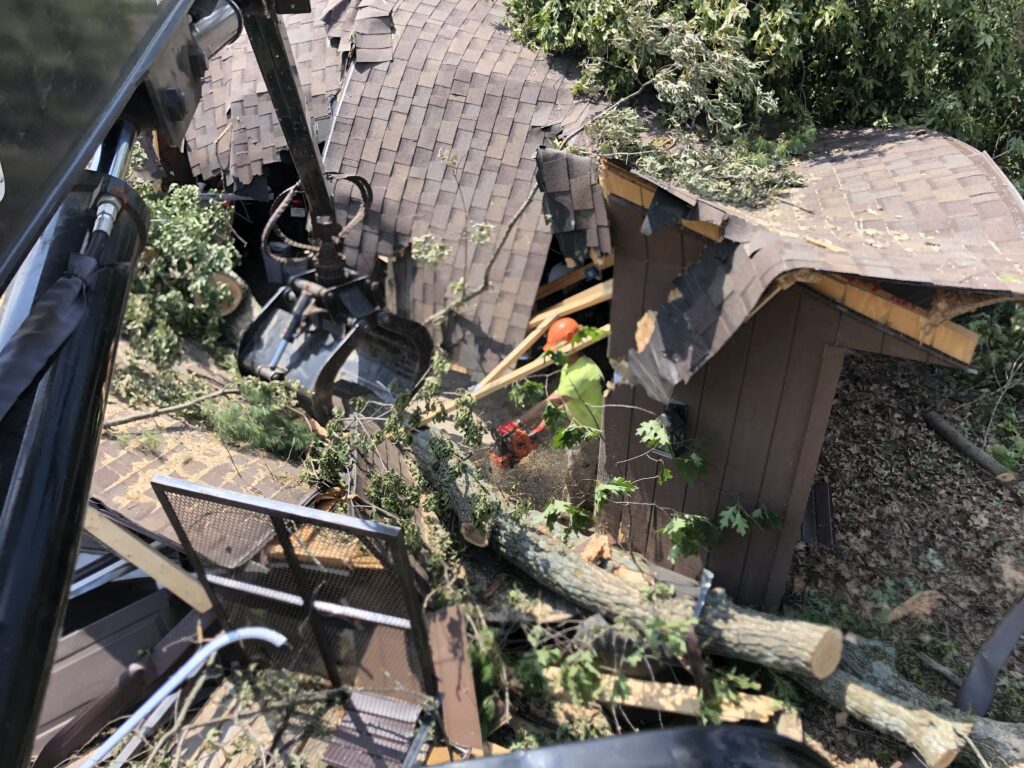 Person cutting up a tree after falling through a roof during a storm in western Wisconsin.