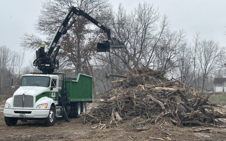 Cleaning up a brush pile with a loader truck in River Falls, WI